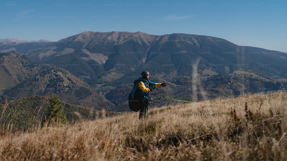 Un pilote de parapente se prépare à voler en montagne.