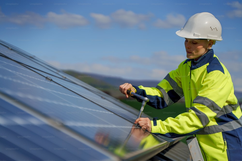Uma engenheira instalando painéis solares fotovoltaicos no telhado, conceito de energia alternativa.