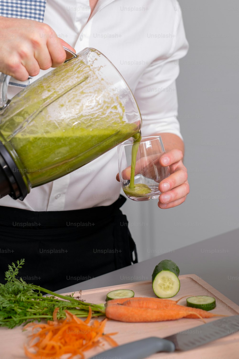 An unrecognizable man making green homemade smoothie in blender. Healthy lifestyle concept.