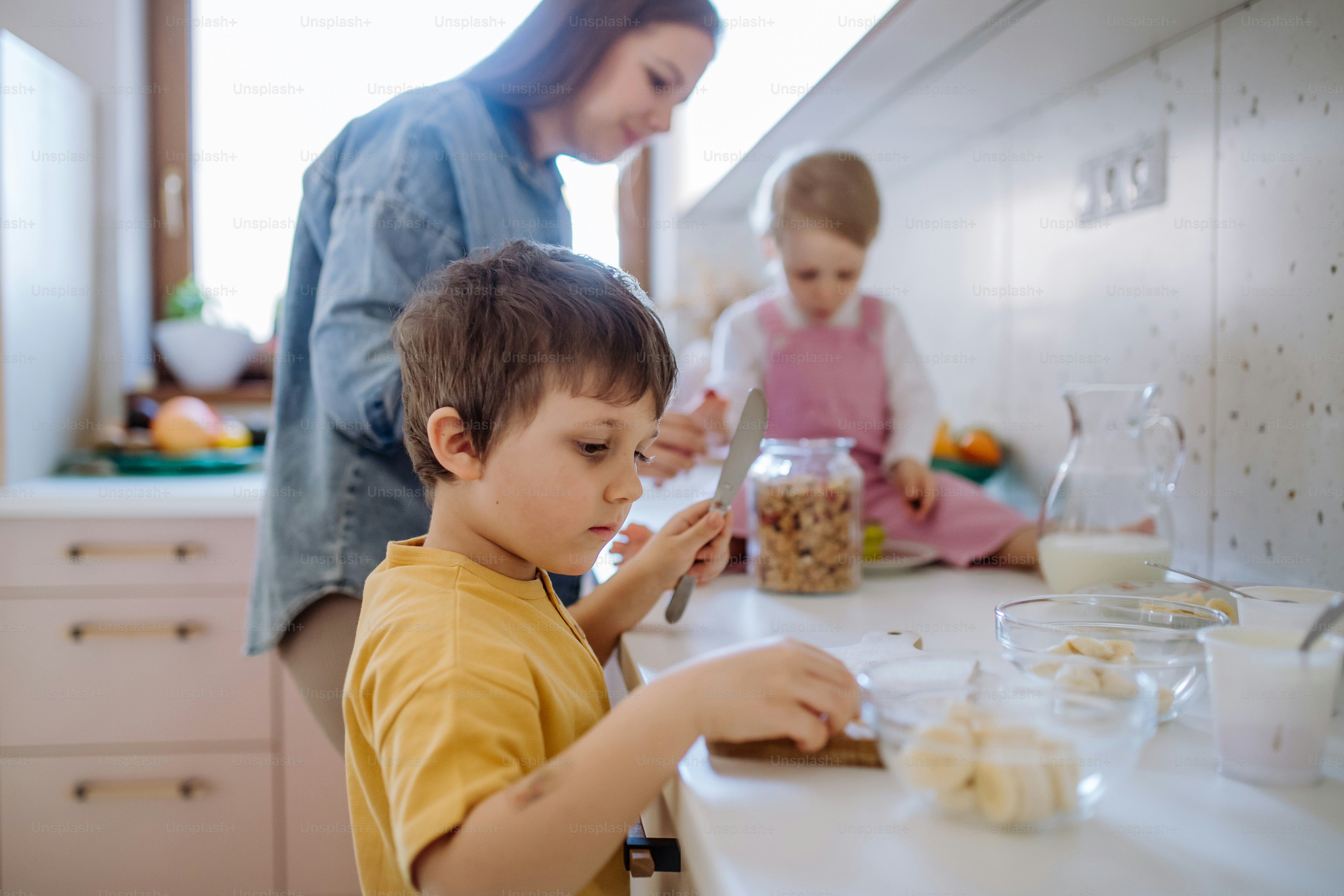 Foto Una madre de dos niños pequeños preparando el desayuno en la ...
