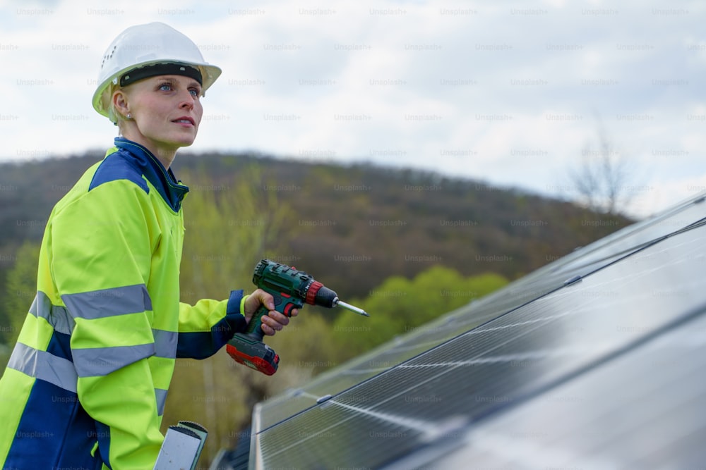 Uma engenheira instalando painéis solares fotovoltaicos no telhado, conceito de energia alternativa.