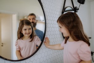 A father having fun with his little daughter, in bathroom at home.