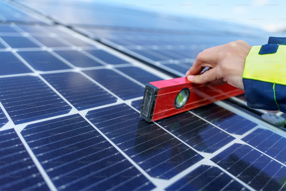 Um close-up de uma engenheira medindo painéis solares fotovoltaicos no telhado, conceito de energia alternativa.