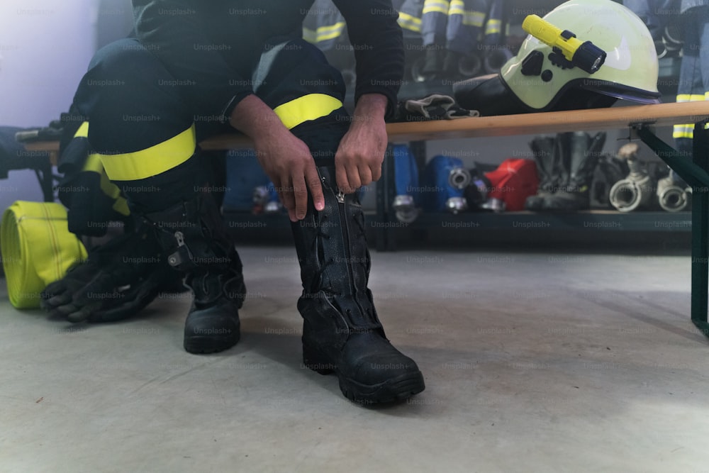 A lowsection of firefighter preparing for action in fire station at night
