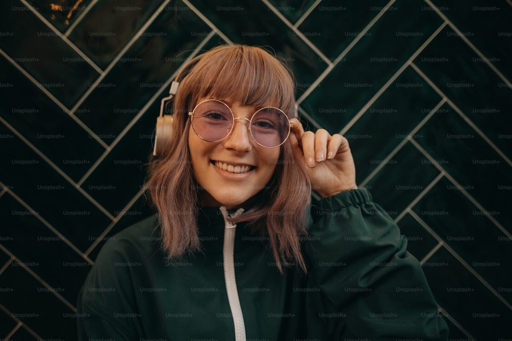 A young woman wearing headphones and enjoying listening to music indoors.