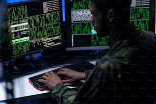 Un hacker dans l’unifrorm militaire sur le dark web, concept de cyberguerre.