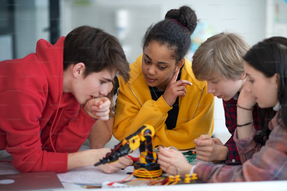 Eine Gruppe von Schülern, die elektrisches Spielzeug und Roboter im Robotik-Klassenzimmer bauen und programmieren