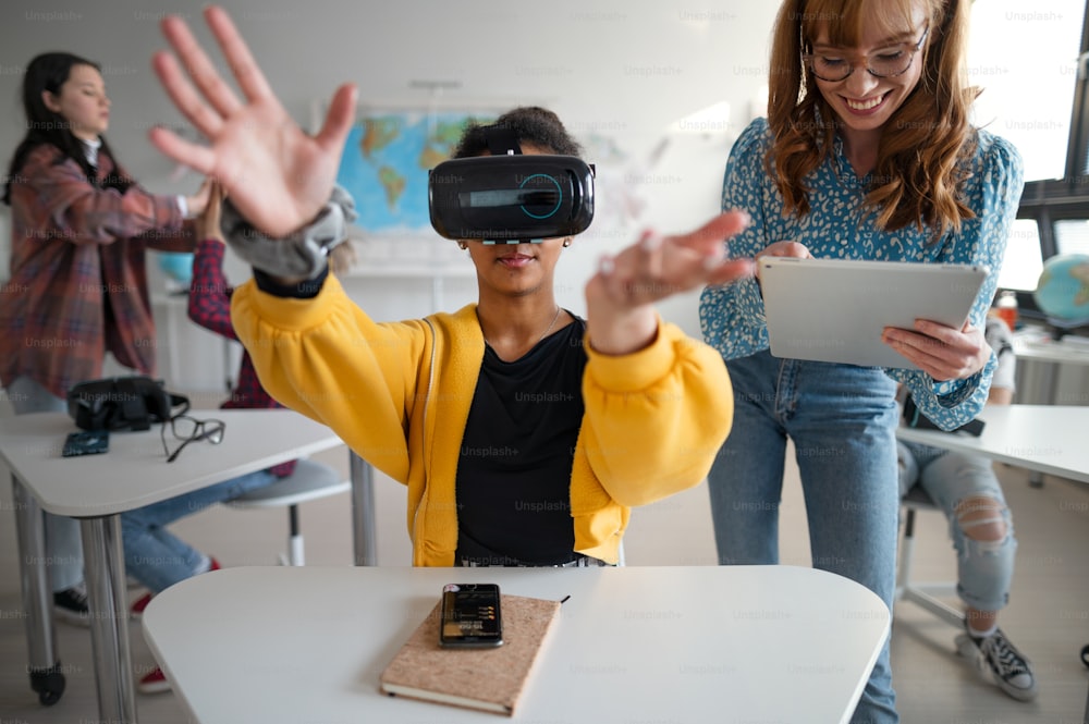 Des adolescents portant des lunettes de réalité virtuelle à l’école dans un cours d’informatique