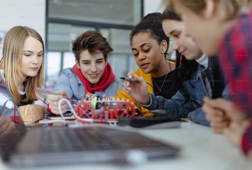 Un grupo de estudiantes de secundaria construyendo y programando juguetes eléctricos y robots en un aula de robótica