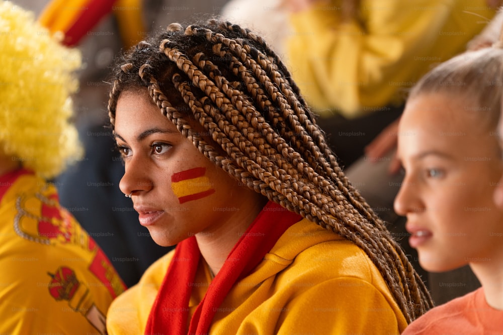 Aficionados al fútbol preocupados apoyando a una selección española en un partido de fútbol en directo en el estadio.