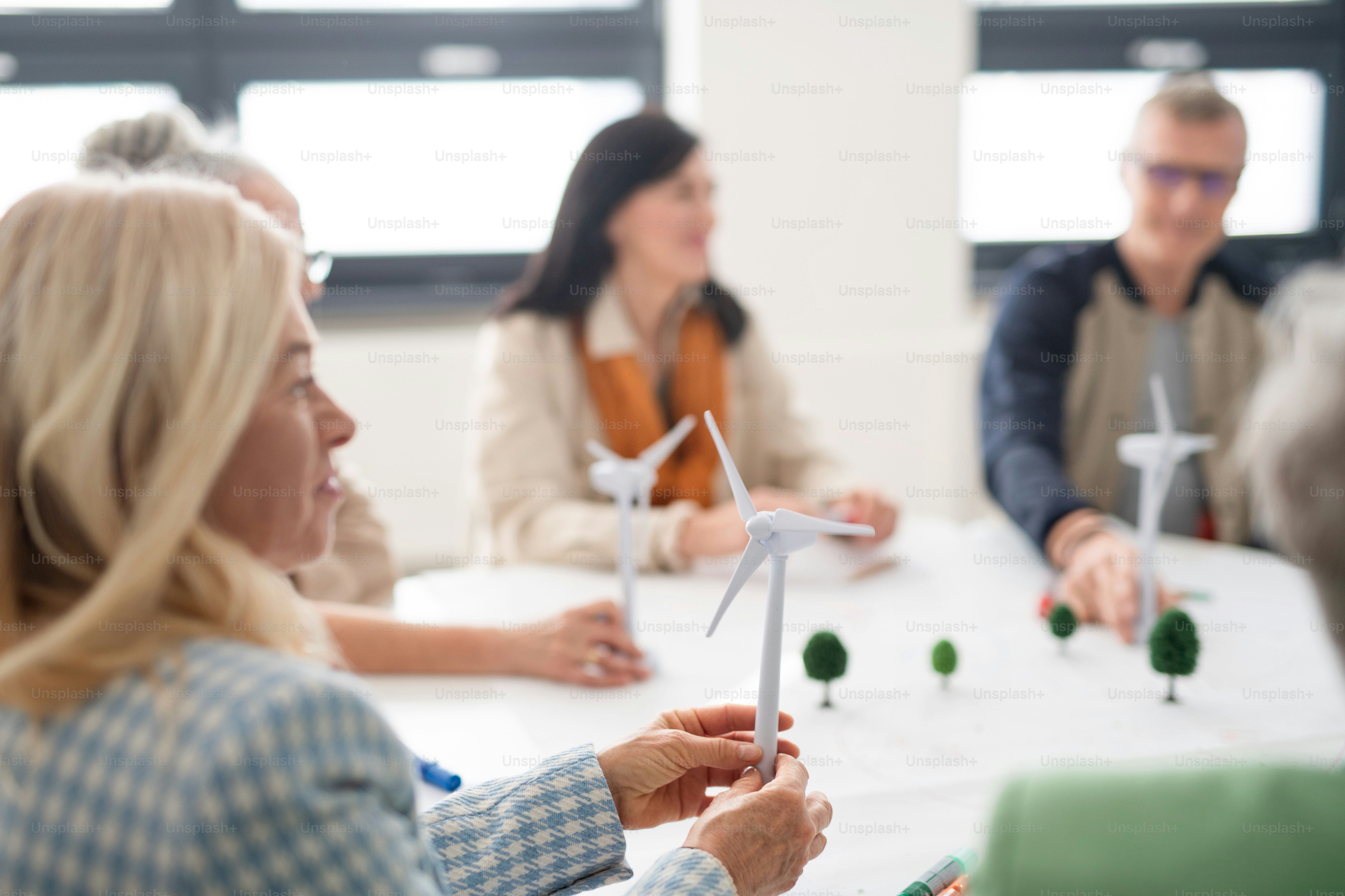A group of senior students discussing about altenrative energy in classroom, close-up.