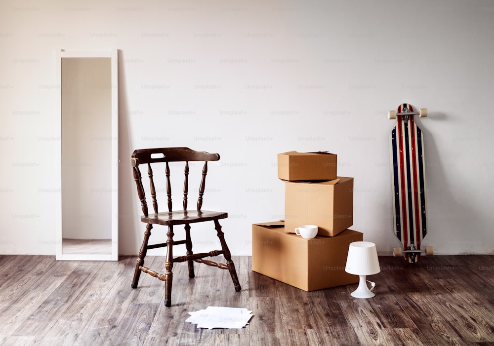 Cajas de cartón empaquetadas, espejos, sillas y otras cosas en la casa vacía. Mudarse en un nuevo concepto de hogar.