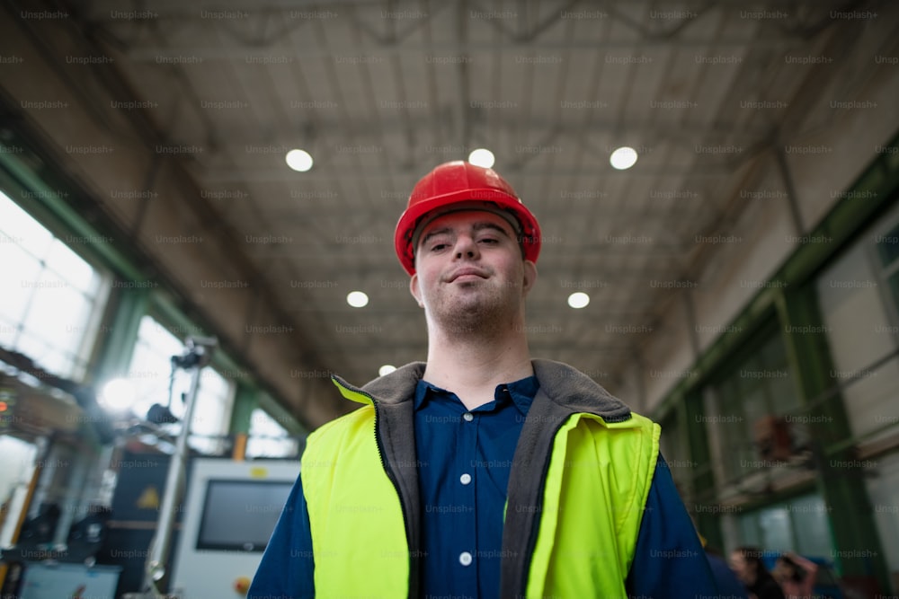 A young man with Down syndrome working in industrial factory, social integration concept.