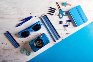 Desk with school supplies. Studio shot on white wooden background.