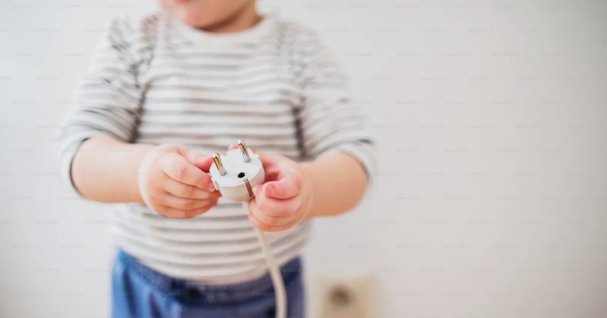 Unrecognizable little toddler playing with a plug. Domestic accident ...