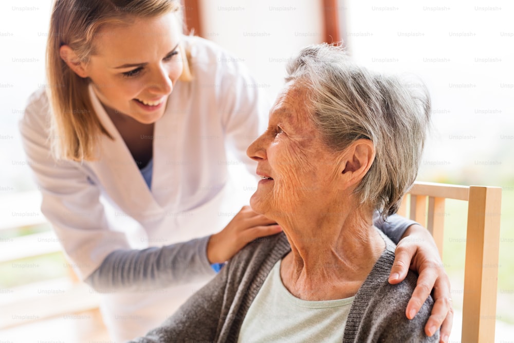 건강 방문자 및 가정 방문 중 노인 여성. 노인 여성과 이야기하는 간호사.