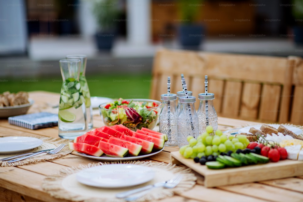 Un tavolo da pranzo apparecchiato per cenare in terrazza in estate, concetto di festa in giardino.