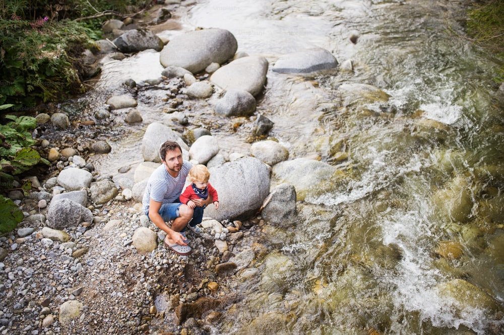 Pai jovem com menino no rio, dia de verão. Vista superior.