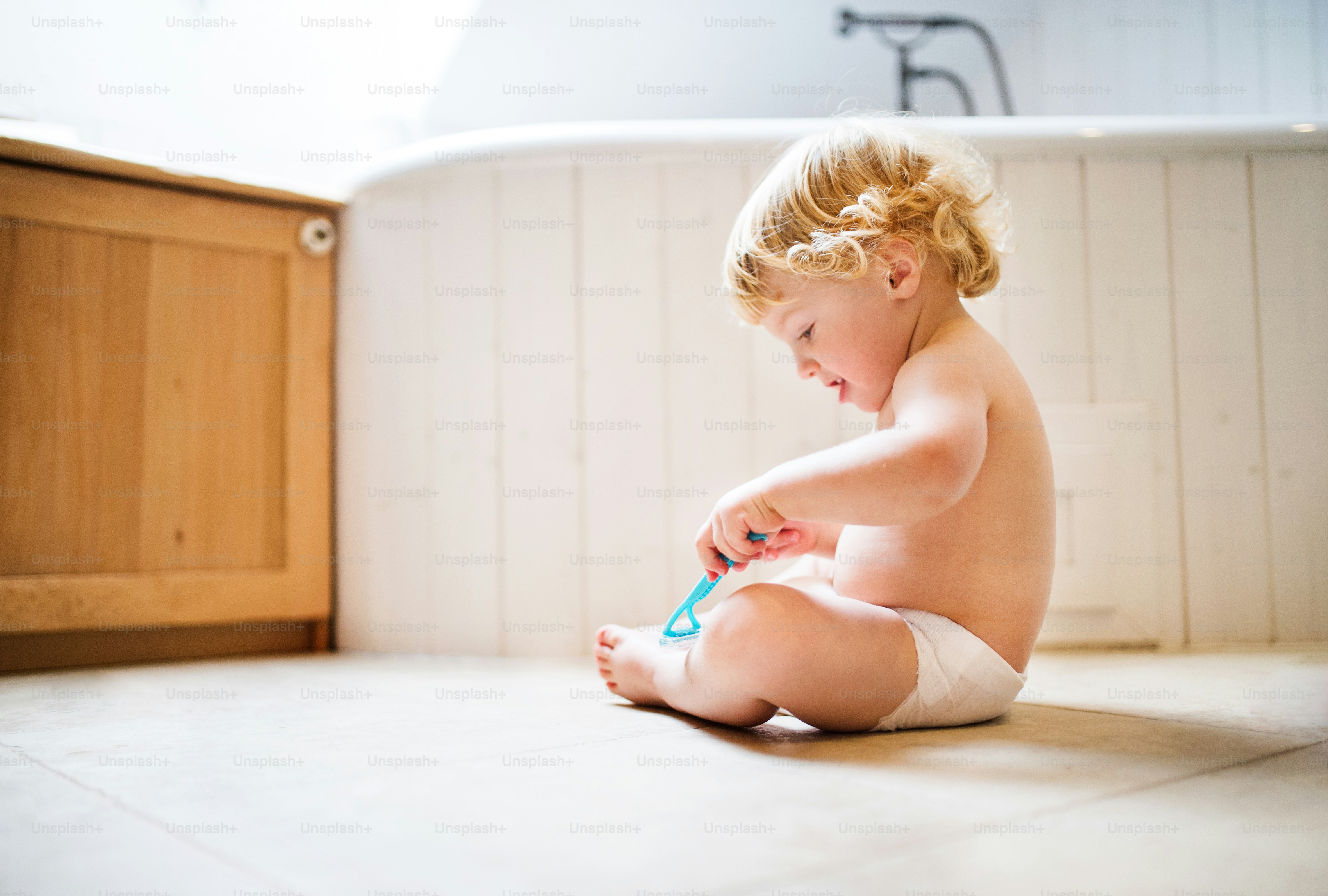 Kleiner Kleinkind mit einem Einwegrasierer. Gefährliche Situation zu Hause. Hausunfall. Kindersicherheitskonzept