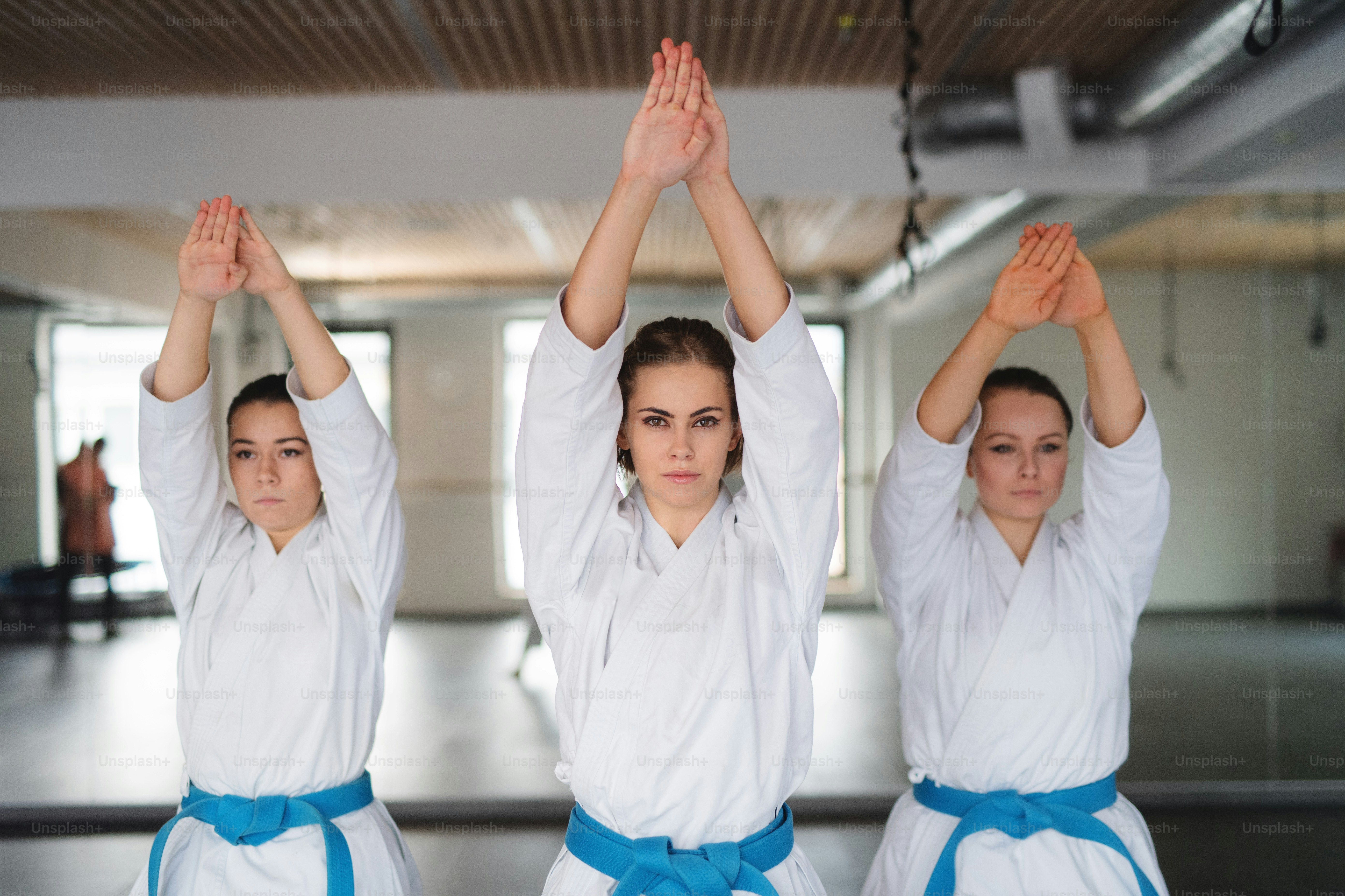 Un gruppo di giovani donne che praticano karate al chiuso in palestra.