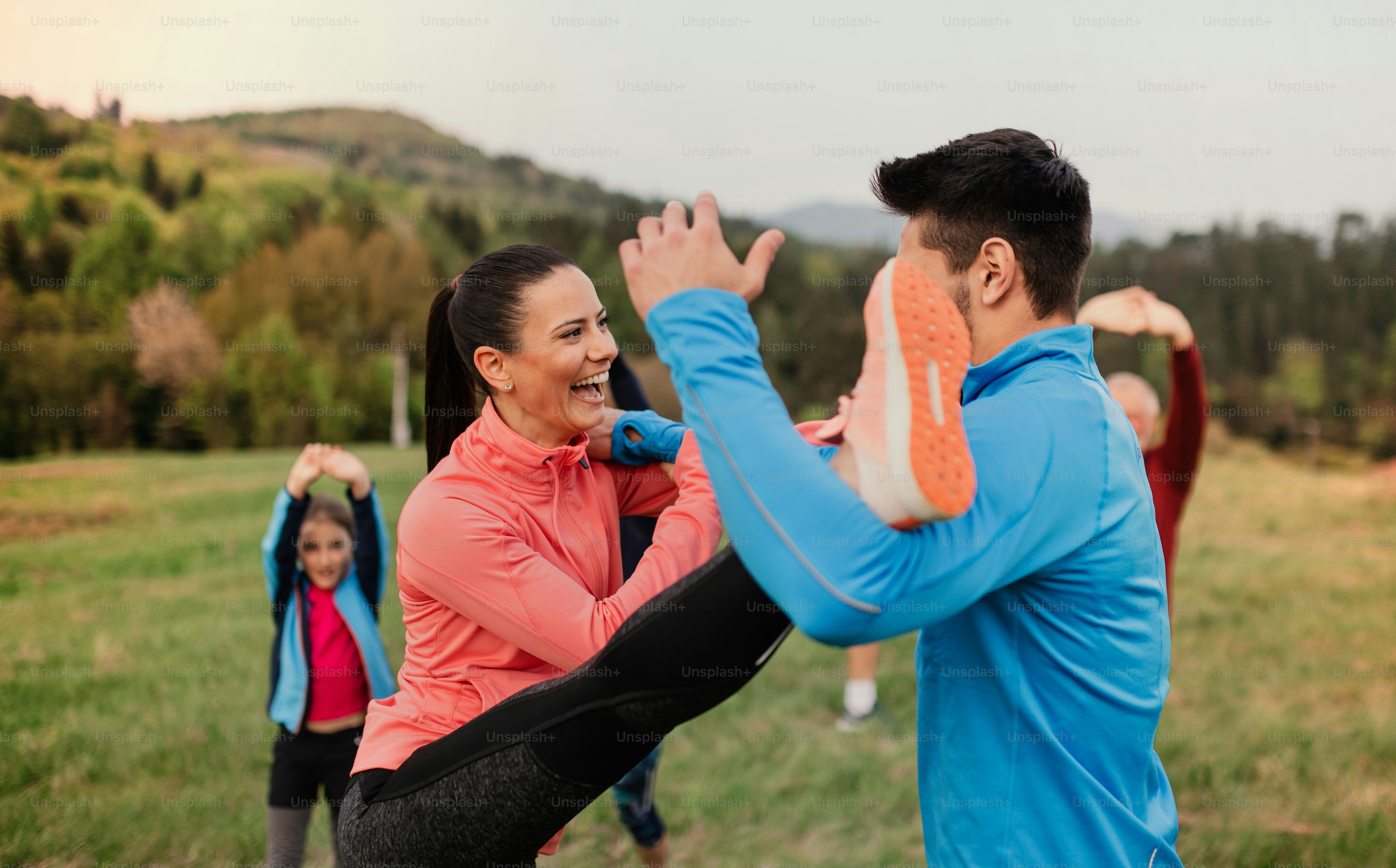 A large group of fit and active people doing exercise in nature. photo ...