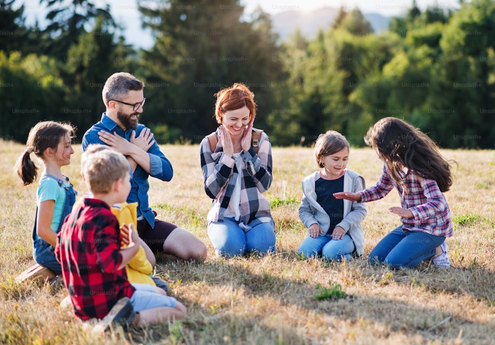 Un gruppo di piccoli scolari con insegnante in gita nella natura.