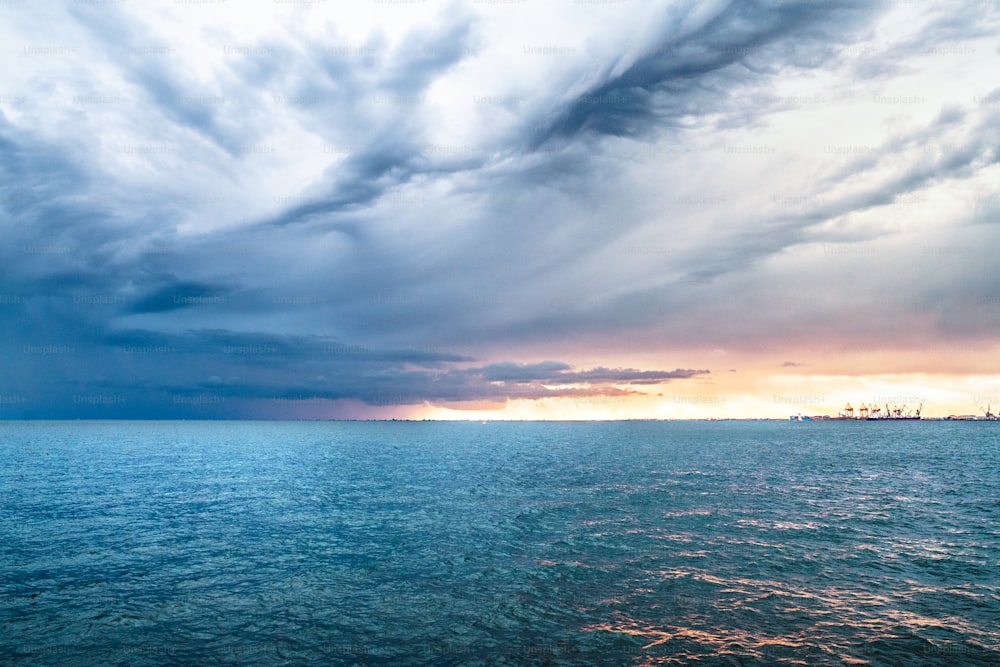 A panoramic view of sea and gray sky at dusk.