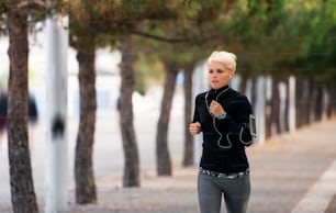 A young sportswoman running outdoors in park. Copy space.