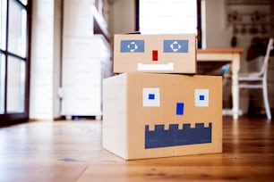 Two cardboard monsters on the floor indoors, diy toy art and craft.