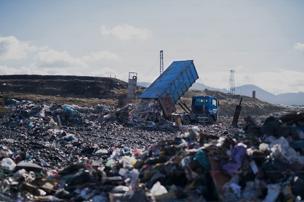 Camion à ordures déchargeant des déchets sur une décharge, concept environnemental. Espace de copie.