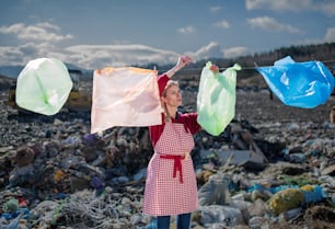 Femme au foyer dans une décharge, concept de consumérisme contre pollution plastique.