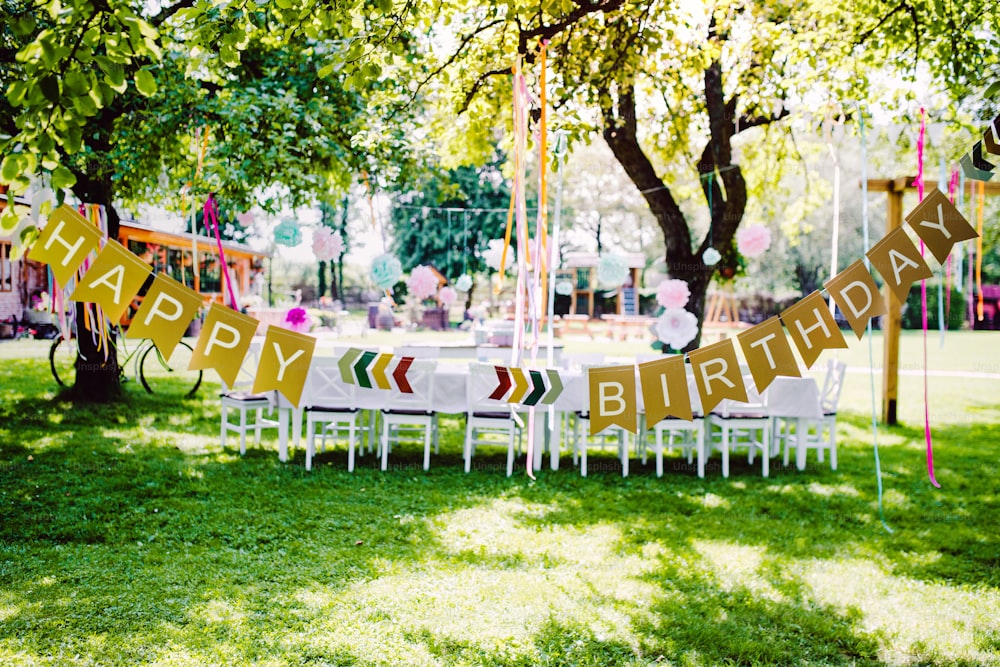 夏の庭で屋外の子供の誕生日パーティー用のテーブルセット、お祝いのコンセプト。