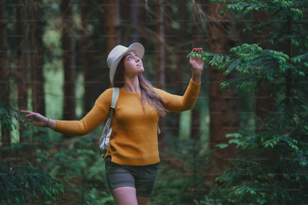 여름 자연 속에서 숲 속에서 야외에서 산책을 하는 젊은 여성의 전면 모습.