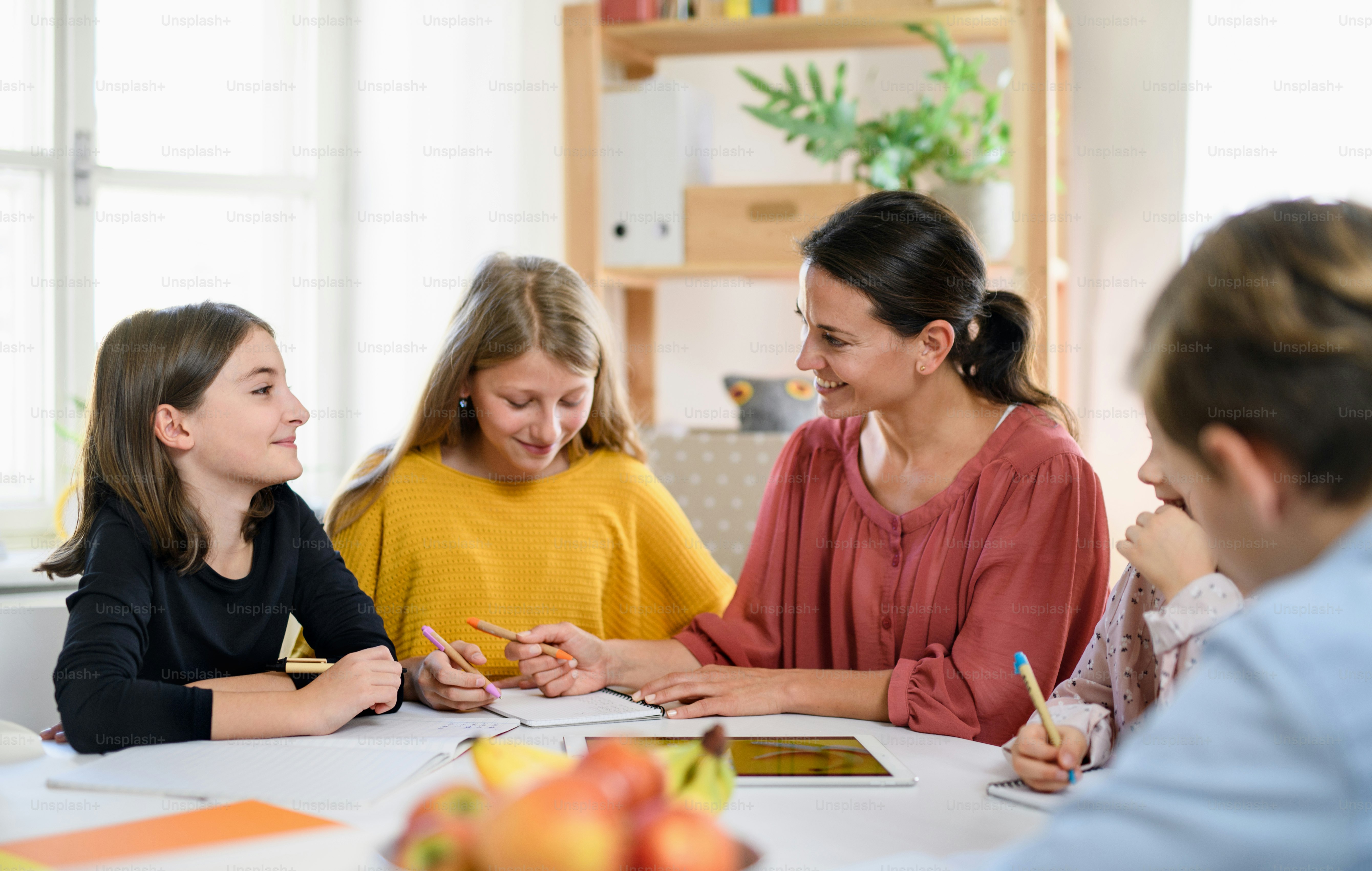 Groupe d’enfants scolarisés à la maison avec un parent enseignant étudiant à l’intérieur, concept de coronavirus.