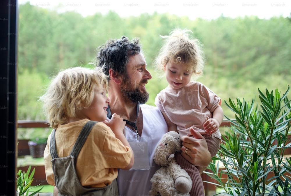 Happy father doctor finally at home meeting his small children, end of coronavirus.