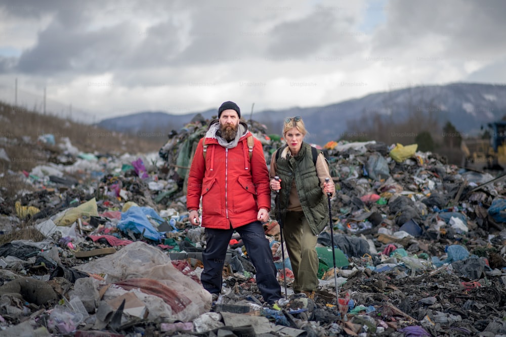 Randonneurs hommes et femmes sur le concept de décharge, d’environnement et de pollution.