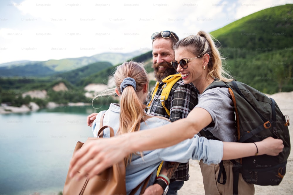 A happy family with preteen daughter on hiking trip on summer holiday, resting.