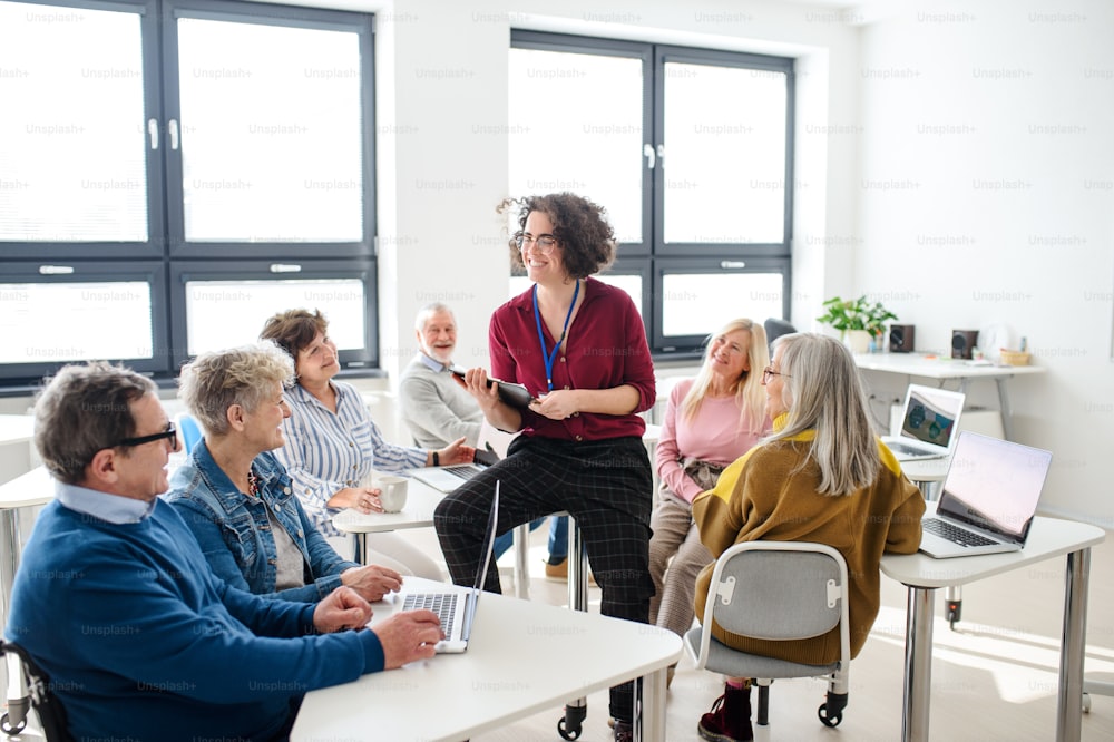 Group of cheerful senior people attending computer and technology education class.