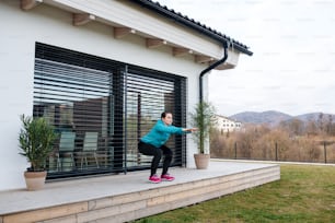 Woman with face masks doing exercise outdoors at home, Corona virus and quarantine concept.