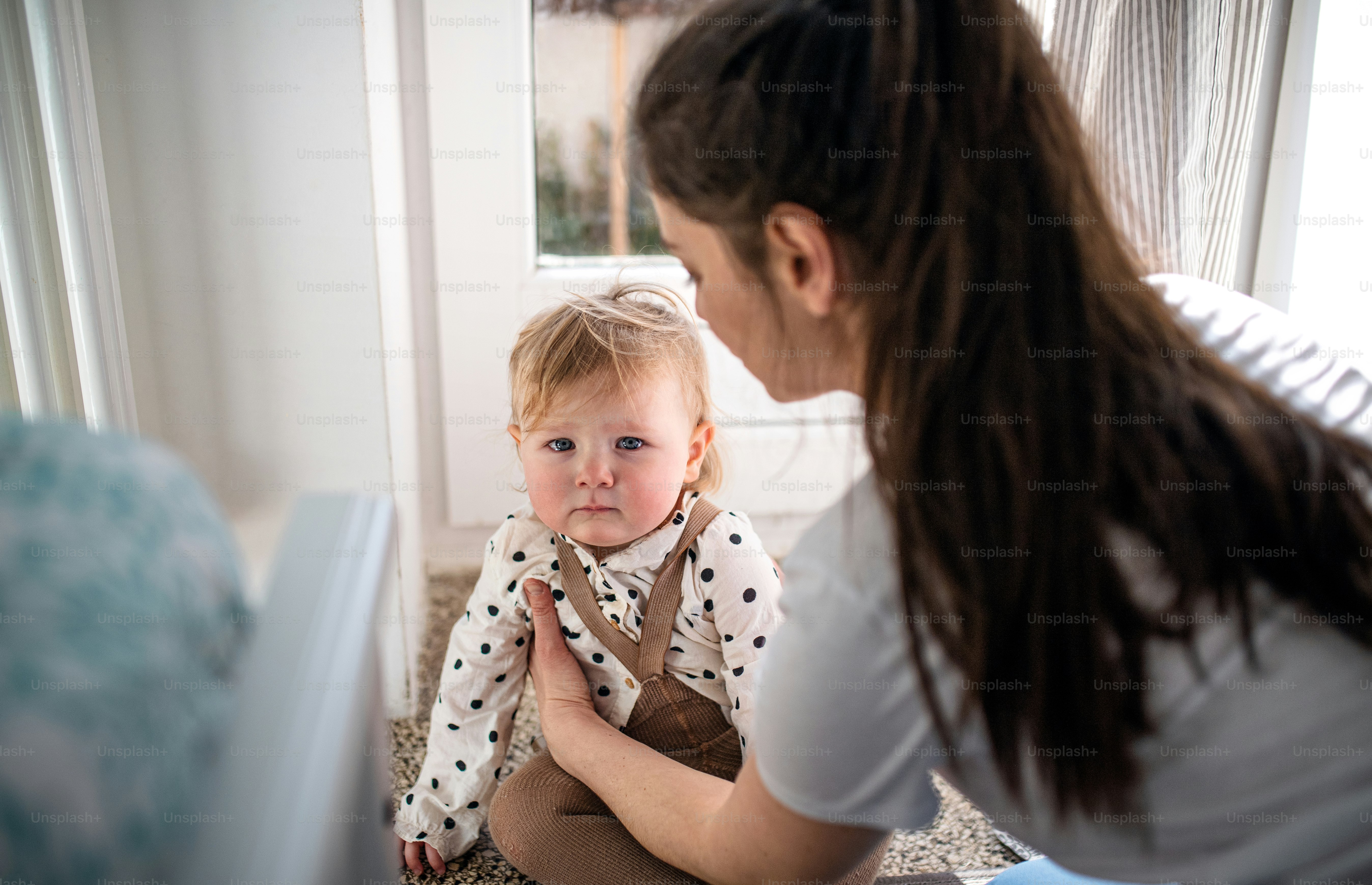 Uma mãe com filha pequena no quarto em casa.