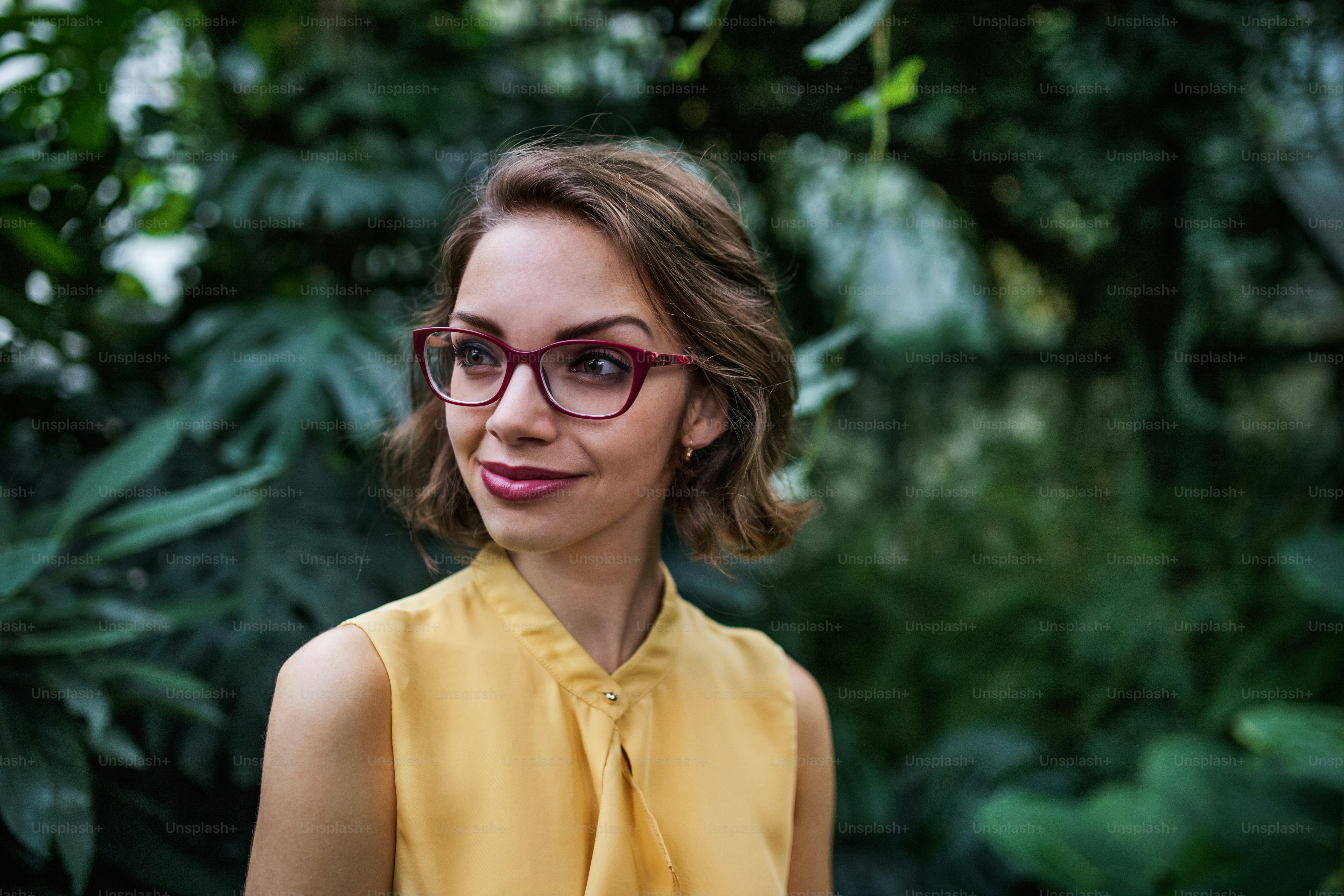 A young woman standing in botanical garden. Copy space
