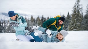 Famille avec petite fille s’amusant en plein air dans la nature hivernale, montagnes Tatra en Slovaquie.