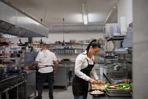 Una chef profesional cortando verduras en el interior de la cocina de un restaurante.