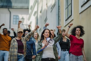 Vue de face d’un groupe de personnes militantes manifestant dans les rues, grève, manifestation et concept de coronavirus.