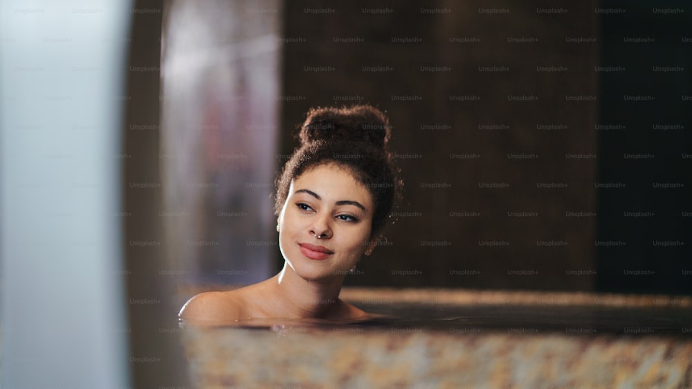 Ritratto di giovane donna felice in piscina coperta, a riposo.