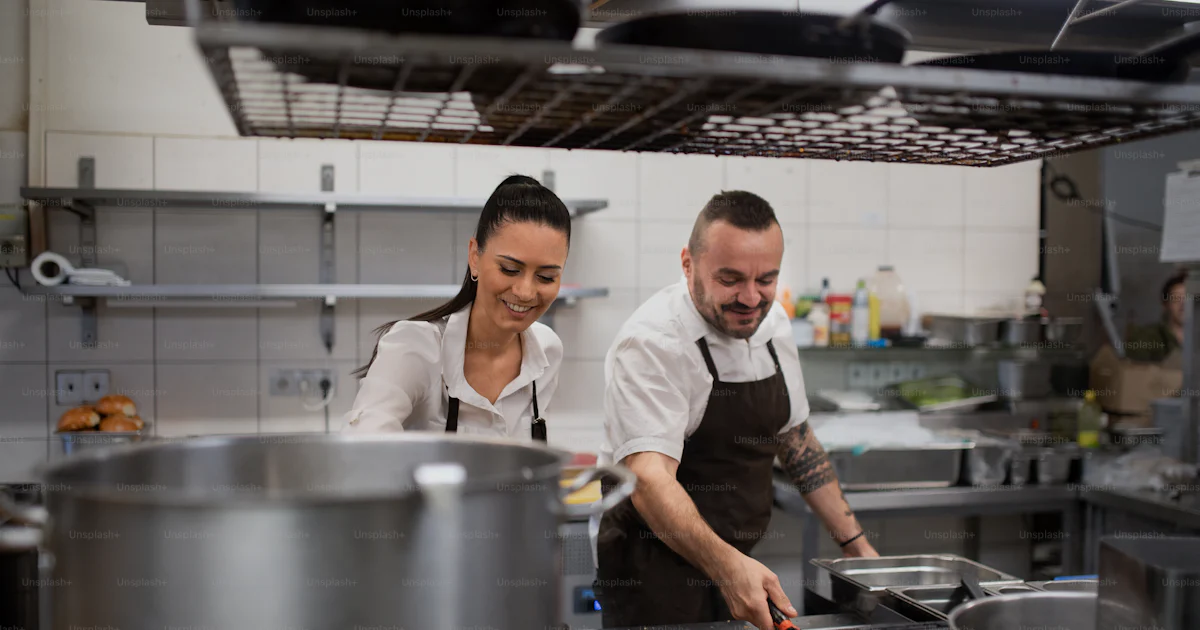 Working Cook A happy chef and cook working on their dishes indoors in restaurant ...