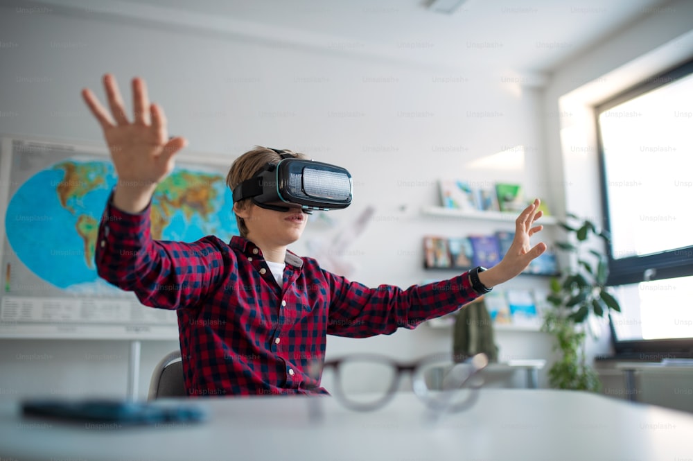 Étudiant curieux portant des lunettes de réalité virtuelle à l’école dans un cours d’informatique