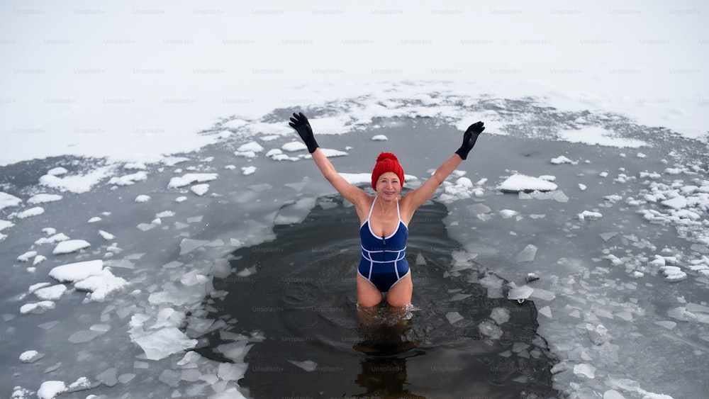 겨울에 야외에서 수영복을 입은 활동적인 노인 여성의 하이 앵글 뷰, 감기 치료 개념.