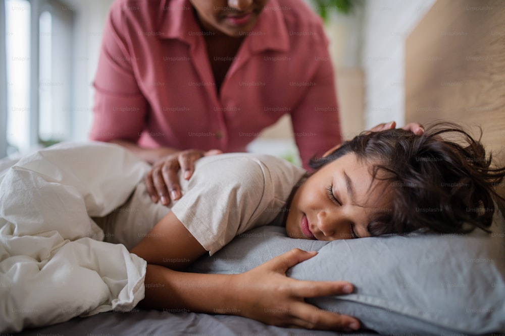 A mother taking care of her ill son at home.