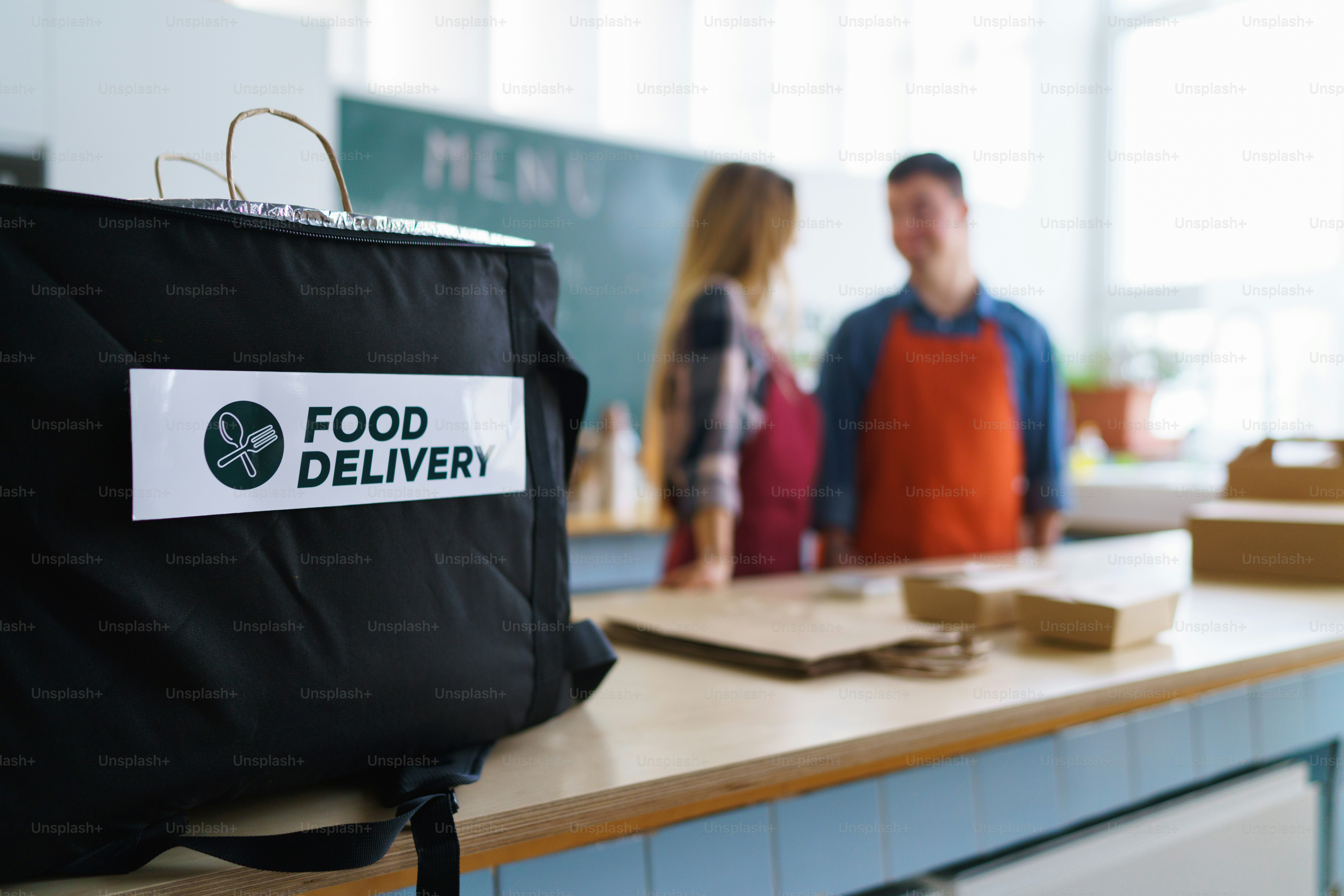 Un joven camarero con síndrome de Down que trabaja con un colega en un restaurante de comida para llevar, concepto de inclusión social.